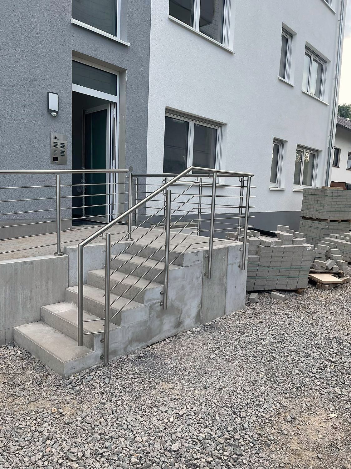 Edelstahlgeländer mit Querstäben an der Außentreppe eines Mehrfamilienhauses