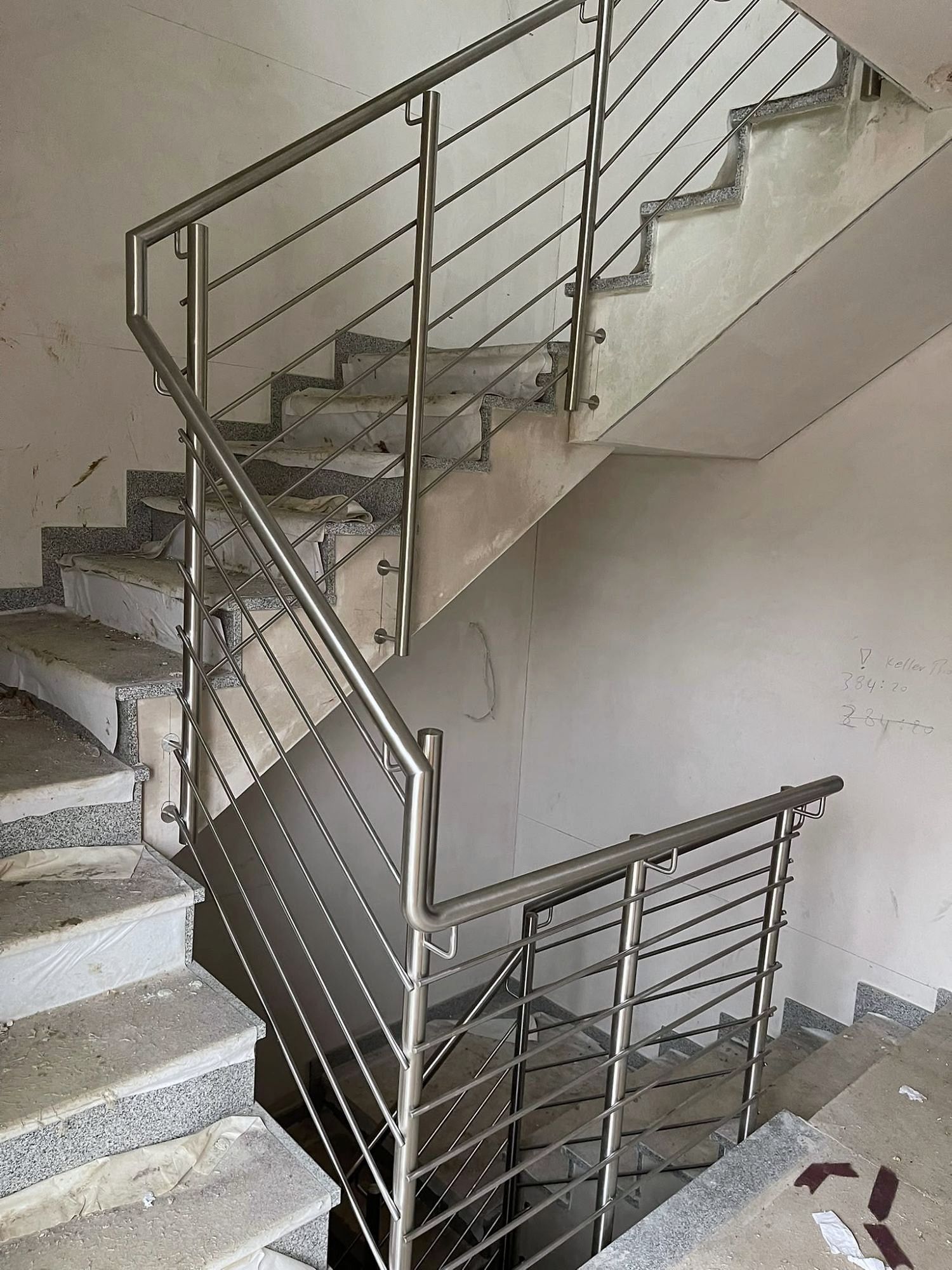 Edelstahlgeländer mit Querstäben über zwei Treppenläufe und ein Podest